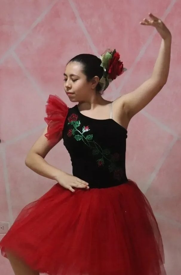 Luciana bailando con tutú rojo y una flor en el cabello